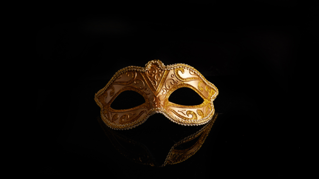 Golden Venetian carnival mask against dark background