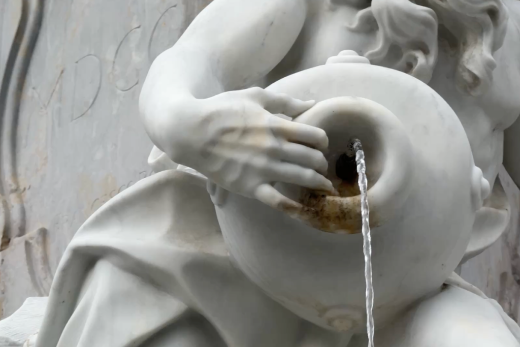 Marble hand holding a vessel with flowing water