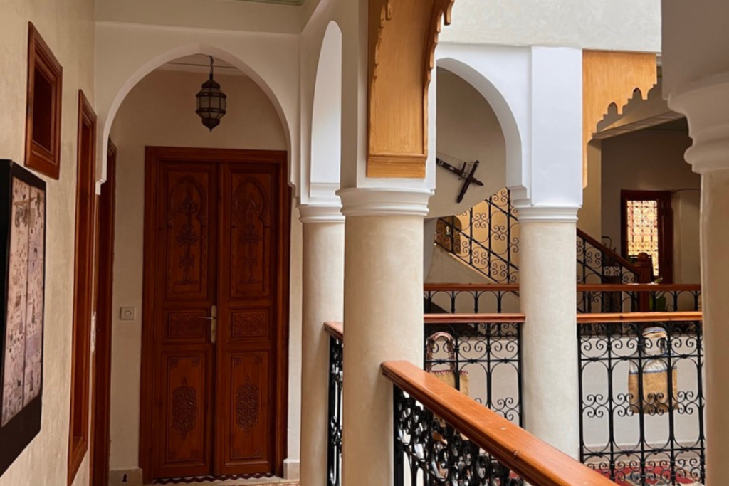 Traditional Moroccan riad interior with staircase, carved doors and enclosed architecture