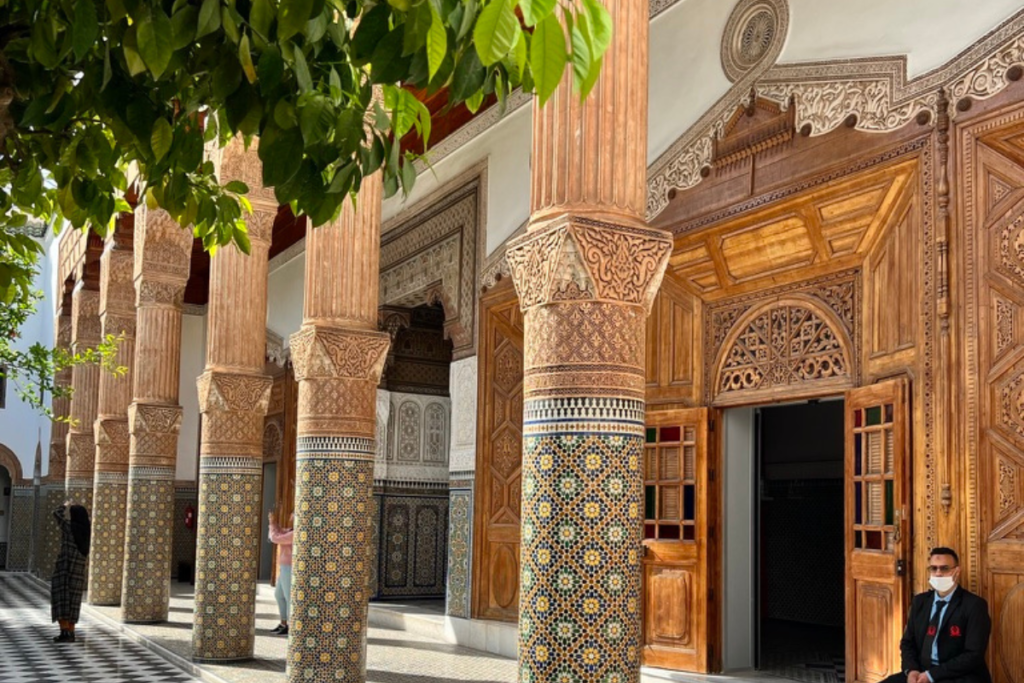 Traditional Moroccan riad architecture with carved wooden doors and mosaic columns