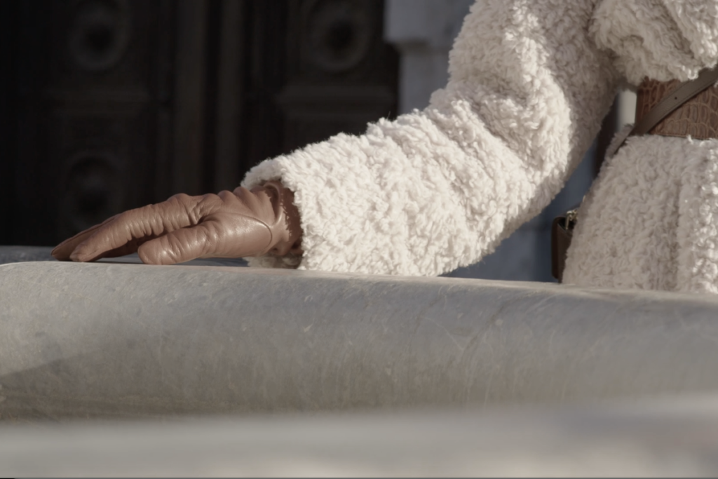 Hand resting on the stone basin of Robba Fountain in Ljubljana
