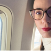 Woman sitting beside an airplane window on a long-haul flight