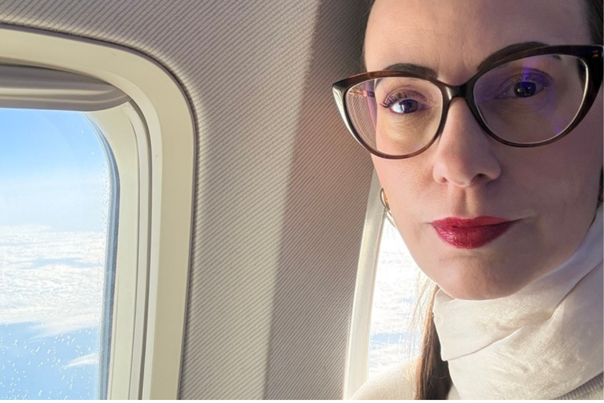 Woman sitting beside an airplane window on a long-haul flight